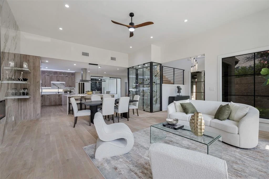 Elysian's open living room, warm wood kitchen, and glass stair enclosure